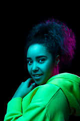 Image showing African-american woman\'s portrait isolated on dark studio background in multicolored neon light