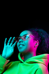 Image showing African-american woman\'s portrait isolated on dark studio background in multicolored neon light