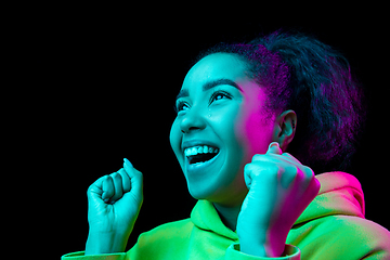 Image showing African-american woman\'s portrait isolated on dark studio background in multicolored neon light