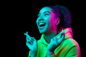 Image showing African-american woman\'s portrait isolated on dark studio background in multicolored neon light