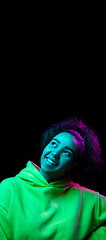 Image showing African-american woman\'s portrait isolated on dark studio background in multicolored neon light