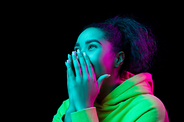 Image showing African-american woman\'s portrait isolated on dark studio background in multicolored neon light