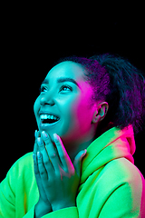 Image showing African-american woman\'s portrait isolated on dark studio background in multicolored neon light