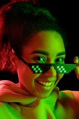 Image showing African-american woman\'s portrait isolated on dark studio background in multicolored neon light