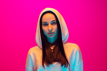 Image showing Caucasian beautiful woman\'s portrait isolated on pink studio background in multicolored neon light