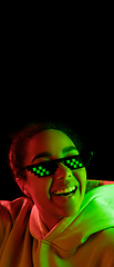 Image showing African-american woman\'s portrait isolated on dark studio background in multicolored neon light