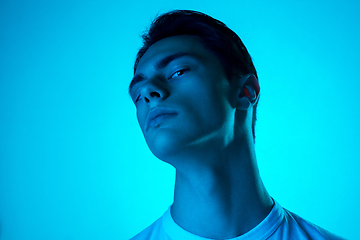 Image showing Handsome caucasian man\'s portrait isolated on blue studio background in neon light, monochrome