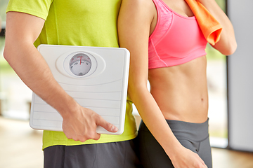 Image showing close up of woman and man with scales in gym