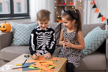 Image showing kids in halloween costumes doing crafts at home