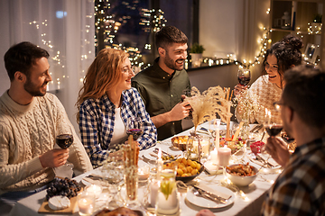 Image showing happy friends drinking red wine at christmas party