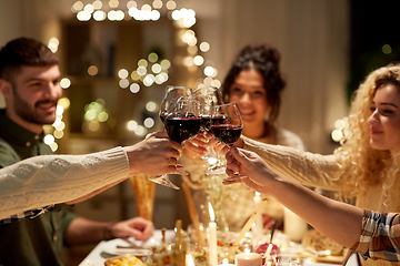 Image showing happy friends drinking red wine at christmas party