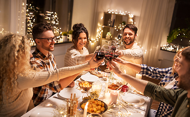 Image showing happy friends drinking red wine at christmas party