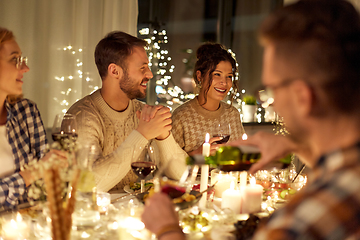 Image showing happy friends drinking red wine at christmas party