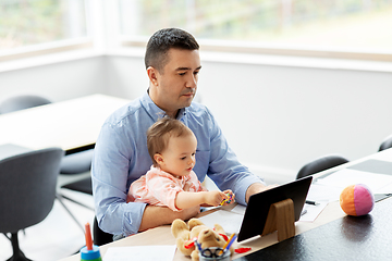 Image showing father with baby working on tablet pc at home