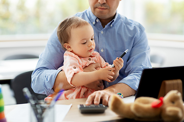 Image showing father with baby working at home