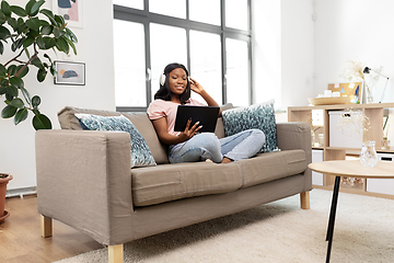 Image showing woman with tablet pc listening to music at home