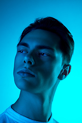 Image showing Handsome caucasian man\'s portrait isolated on blue studio background in neon light, monochrome