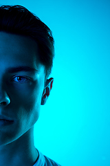 Image showing Handsome caucasian man\'s portrait isolated on blue studio background in neon light, monochrome