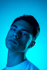 Image showing Handsome caucasian man\'s portrait isolated on blue studio background in neon light, monochrome