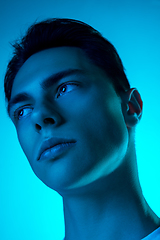 Image showing Handsome caucasian man\'s portrait isolated on blue studio background in neon light, monochrome