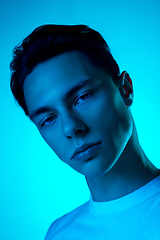 Image showing Handsome caucasian man\'s portrait isolated on blue studio background in neon light, monochrome
