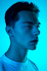 Image showing Handsome caucasian man\'s portrait isolated on blue studio background in neon light, monochrome