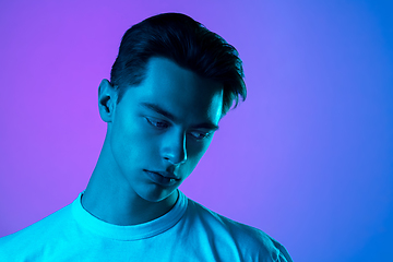 Image showing Handsome caucasian man\'s portrait isolated on purple studio background in neon light, monochrome