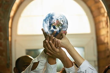 Image showing Doctors holding a world globe in hands, concept of world health, supporting