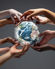 Image showing Hands holding planet Earth, close up on grey background. Environment save, taking care of nature and ecology, supporting hands concept