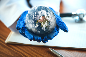 Image showing Doctor holding a world globe in hands, concept of world health, supporting