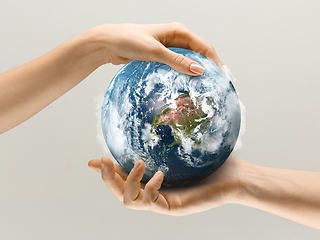 Image showing Hands holding planet Earth, close up. Environment save, taking care of nature and ecology, supporting hands concept