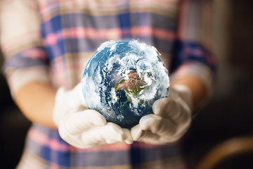 Image showing Hands holding planet Earth, close up. Environment save, taking care of nature and ecology, supporting hands concept