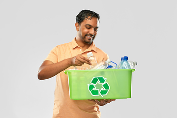 Image showing smiling young indian man sorting plastic waste