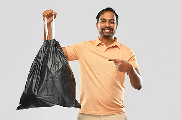 Image showing smiling indian man holding trash bag