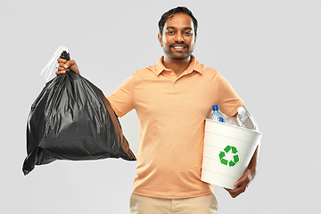 Image showing smiling indian man sorting paper and plastic waste