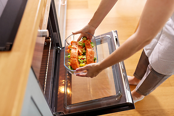 Image showing woman cooking food in oven at home kitchen