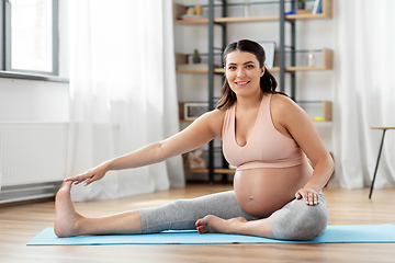 Image showing happy pregnant woman doing sports at home