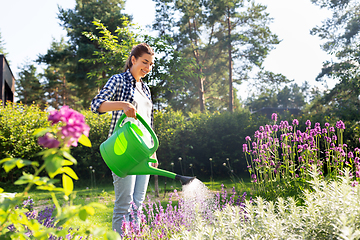 Image showing young woman watering flowers at garden