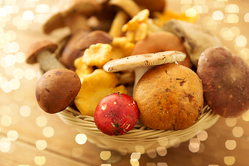 Image showing basket of different edible mushrooms on wood