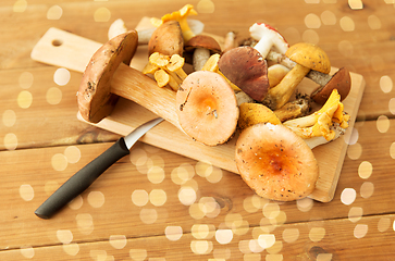 Image showing edible mushrooms on wooden cutting board and knife