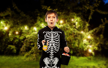 Image showing boy in halloween costume with candies and torch