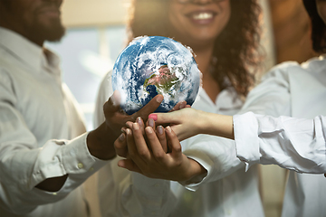 Image showing Doctors holding a world globe in hands, concept of world health, supporting