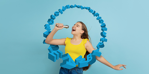 Image showing Girl shouting, singing with speaker, microphone on studio background. Sales, offer, business, cheering fun concept.