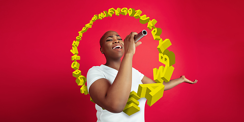 Image showing Woman shouting, singing with speaker, microphone on studio background. Sales, offer, business, cheering fun concept.