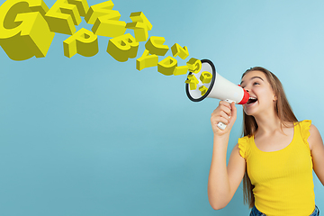 Image showing Girl shouting with megaphone, loudspeaker on studio background. Sales, offer, business, cheering fun concept.