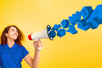Image showing Girl shouting with megaphone, loudspeaker on studio background. Sales, offer, business, cheering fun concept.
