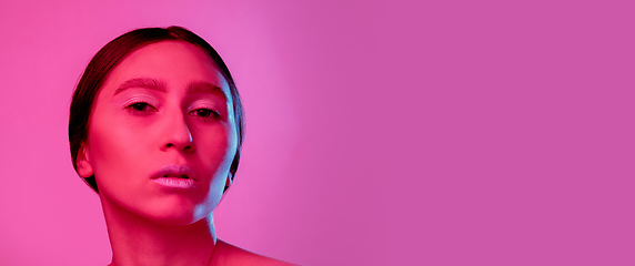 Image showing Beautiful east woman portrait isolated on pink studio background in neon light, monochrome