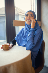 Image showing Beautiful arab woman meeting at cafe or restaurant with friend, spending time with cup of tea