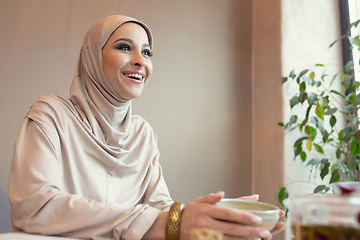 Image showing Beautiful arab woman meeting at cafe or restaurant with friend, spending time with cup of tea