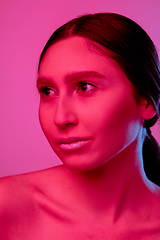 Image showing Beautiful east woman portrait isolated on pink studio background in neon light, monochrome